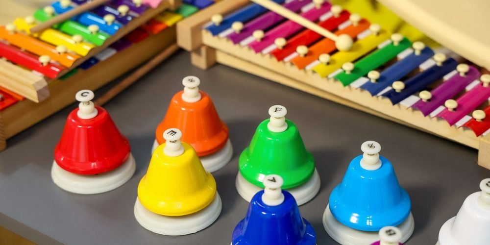 Vibrant xylophones and hand bells arranged on a table, ideal for music education themes.